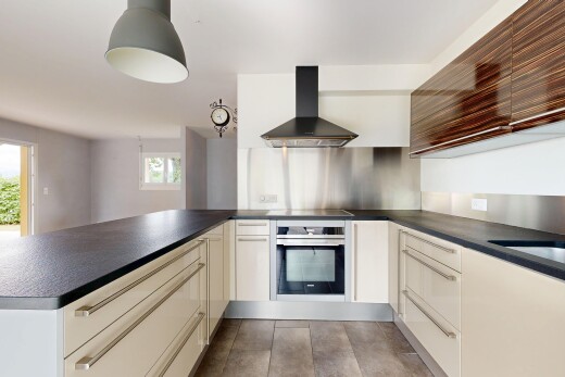 cuisine avec hotte, plans de travail, dark countertops, four, et péninsule de cuisine