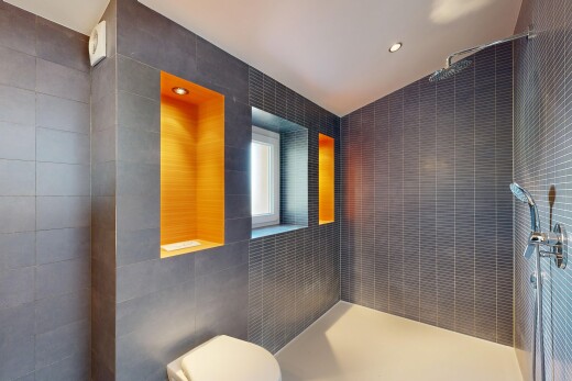 salle de bains avec tile wall, mur en carrelage, vaulted ceiling, plafond voûté, et salle de bain complète