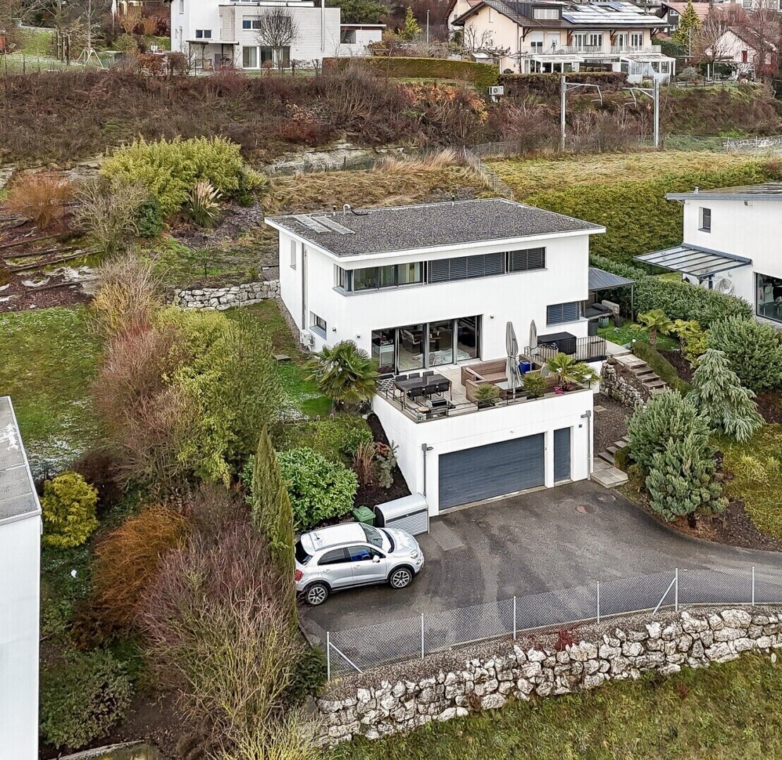 außenansicht mit property visible, stuckverkleidung, auffahrt, eingebaute garage, und zaun