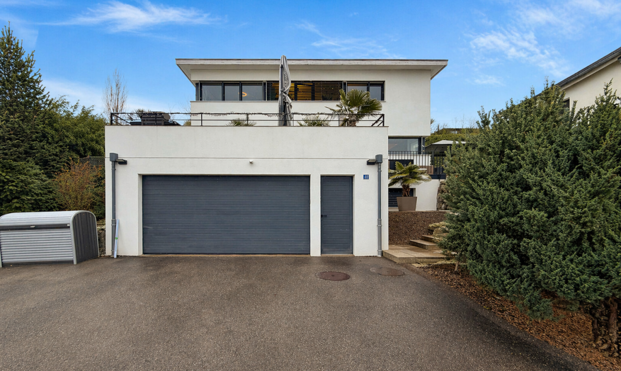 außenansicht mit stuckverkleidung, garage, property visible, auffahrt, und day time