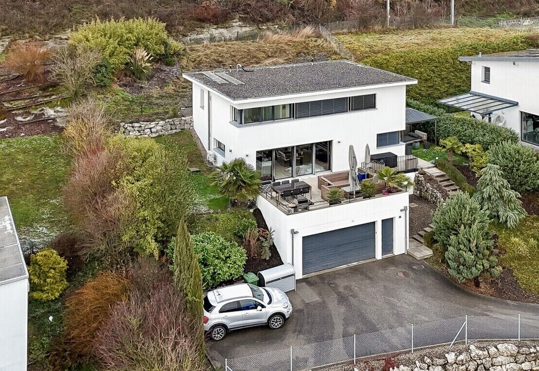 außenansicht mit property visible, stuckverkleidung, auffahrt, eingebaute garage, und zaun