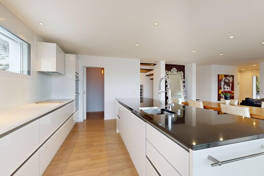 cuisine avec armoires blanches, armoires à panneau plat, wood finish floor, sol en finition bois, et inside property