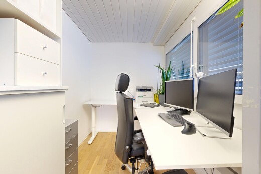 bureau avec télévision, wood finish floor, sol en finition bois, drywall, et cloison sèche