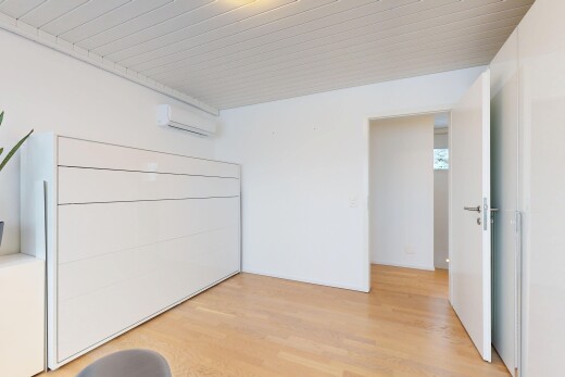 pièce vide avec drywall, cloison sèche, wood finish floor, sol en finition bois, et climatiseur mural