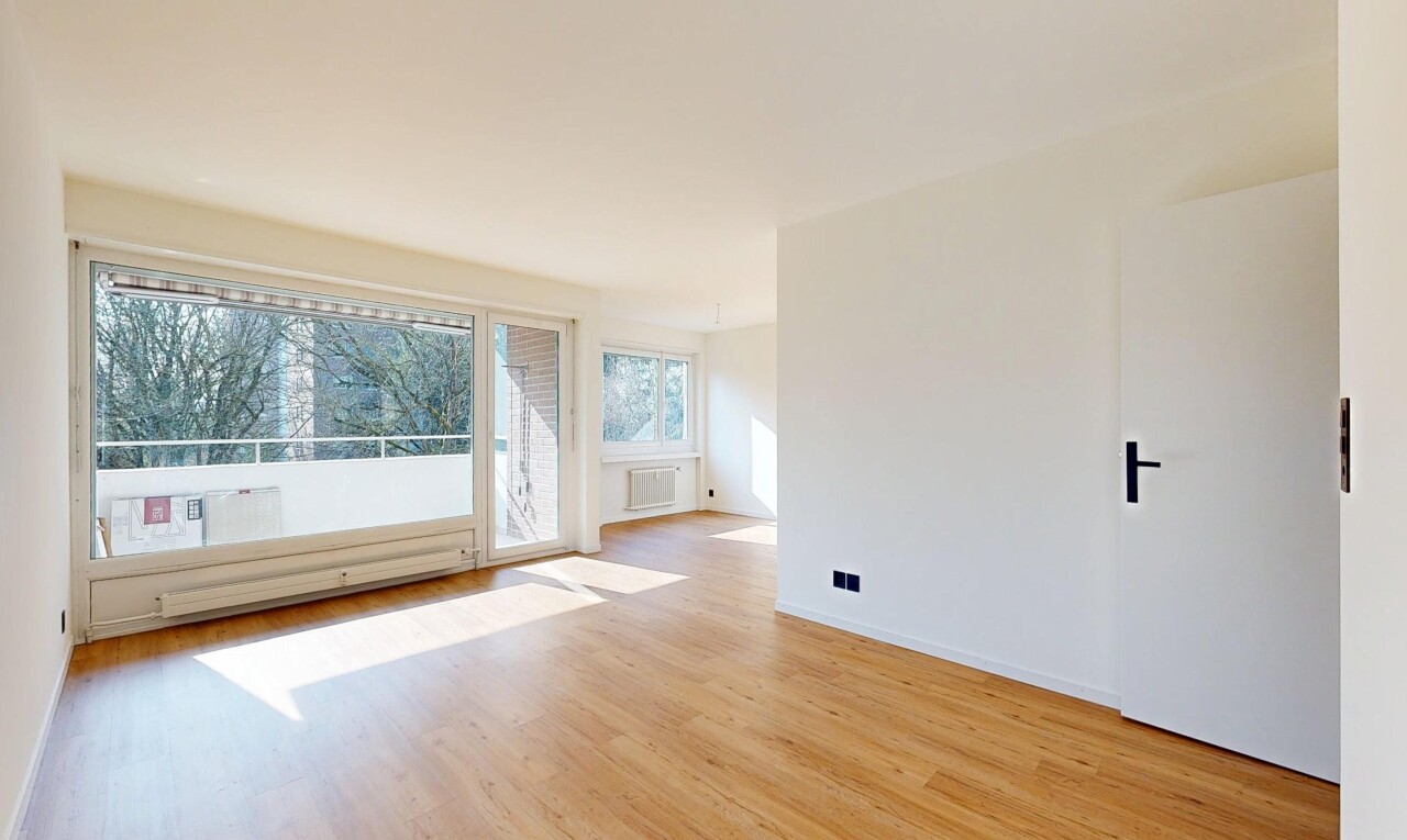 unfurnished room with light wood-type flooring and a baseboard radiator