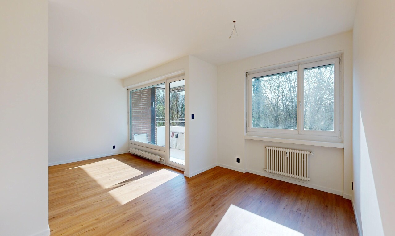 empty room with radiator, light wood-type flooring, and plenty of natural light