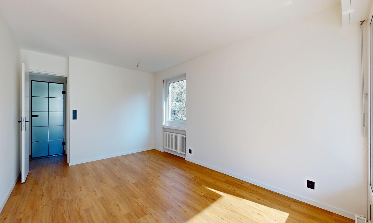 empty room featuring light wood-type flooring and radiator heating unit