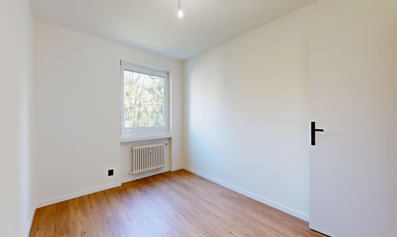 unfurnished room with radiator and light wood-type flooring