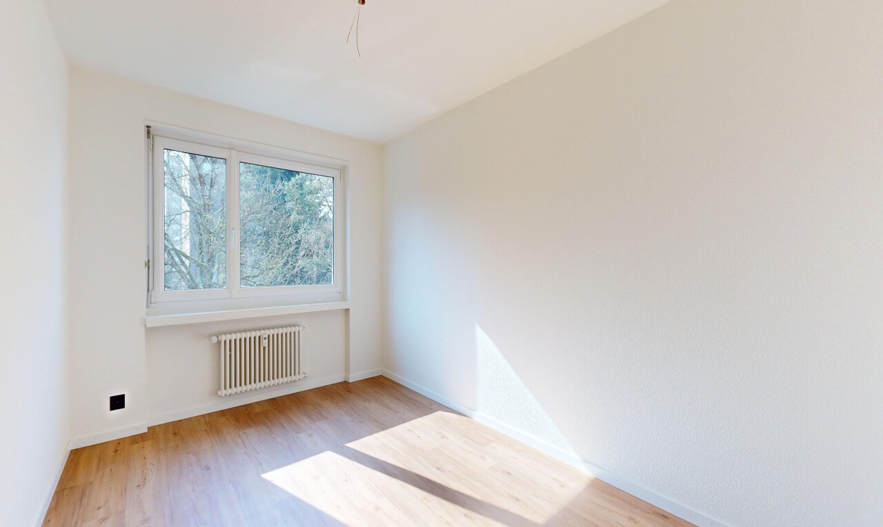 spare room with radiator heating unit and light wood-type flooring