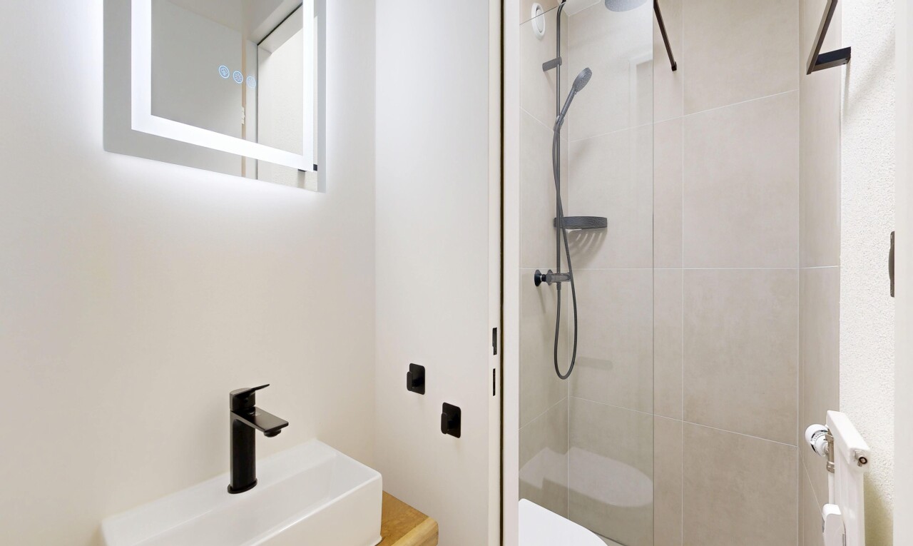 full bathroom with vanity, a stall shower, and radiator