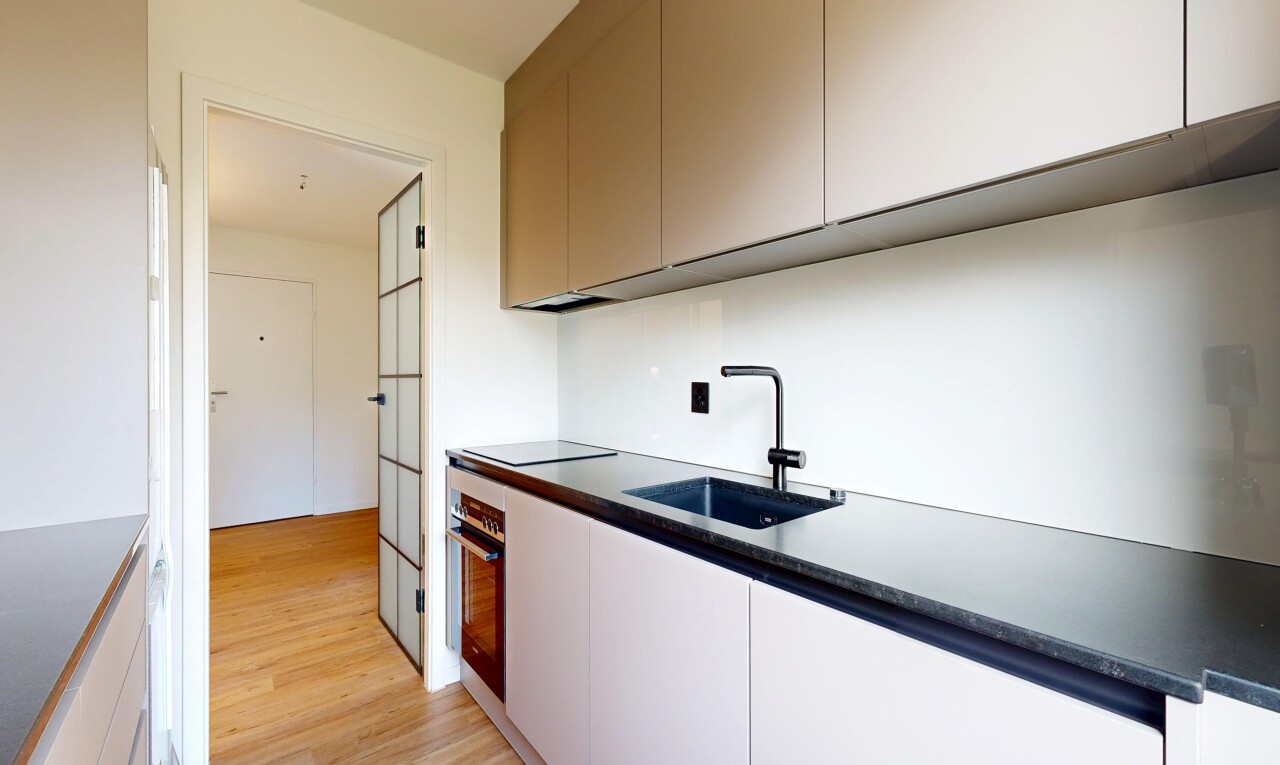 kitchen featuring dark countertops, light wood finished floors, oven, modern cabinets, and black electric stovetop