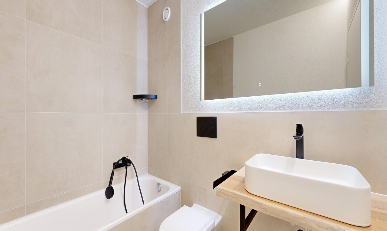 bathroom with tile walls and a garden tub