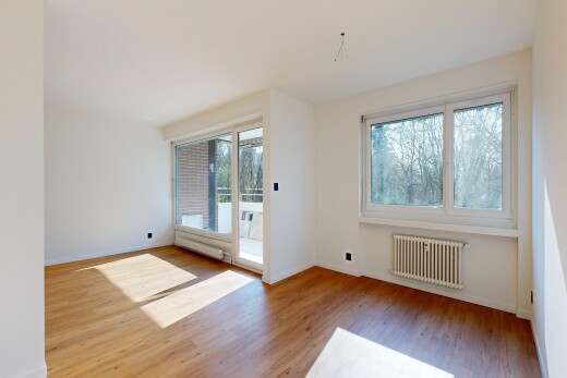 pièce vide avec radiateur, cloison sèche, drywall, sol en finition bois, et wood finish floor