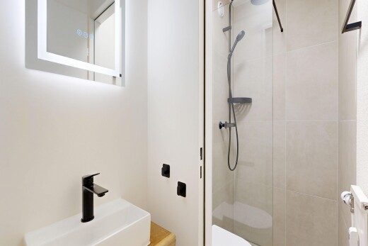 full bathroom with vanity, a stall shower, and radiator