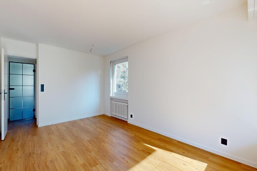empty room featuring light wood-type flooring and radiator heating unit
