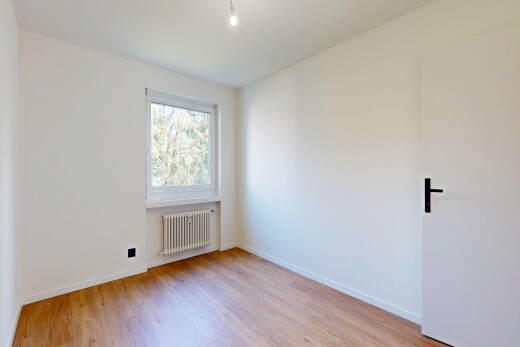 unfurnished room with radiator and light wood-type flooring