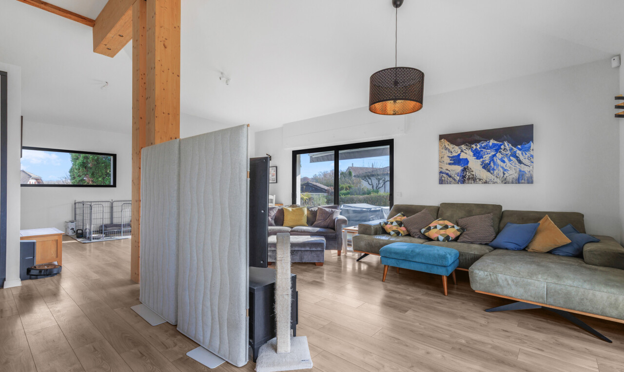 salon avec wood finish floor, sol en finition bois, drywall, cloison sèche, et natural light