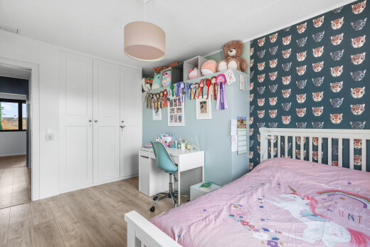 zimmer / schlafzimmer mit inside property, holzfußboden, wood finish floor, kleiderschrank, und natürliches licht