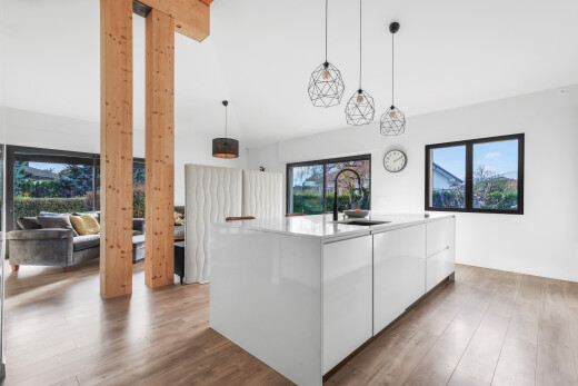 küche mit schränke mit flachen paneelen, pendelleuchte, weiße schränke, wood finish floor, und holzfußboden