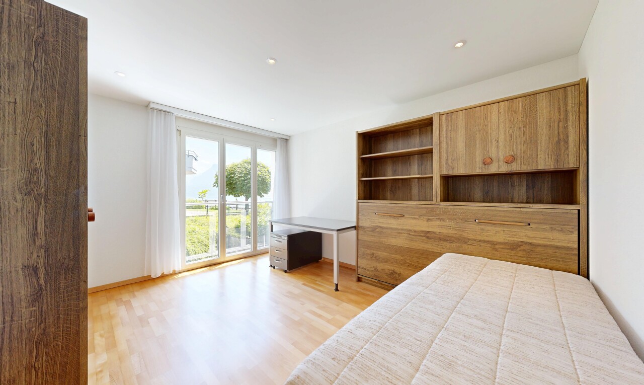 zimmer / schlafzimmer mit holzfußboden, wood finish floor, gipskartonwand, drywall, und natürliches licht