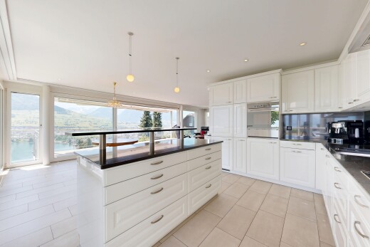 kitchen featuring white cabinetry, a kitchen island, stainless steel oven, decorative light fixtures, and a mountain view