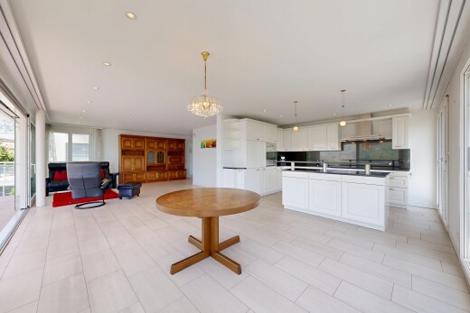 kitchen with open floor plan, white cabinetry, a center island with sink, suspended lighting, and decorative backsplash