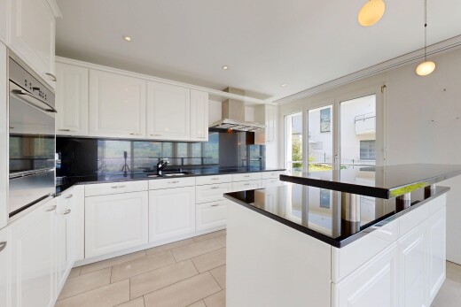 kitchen featuring a center island, backsplash, white cabinetry, oven, and decorative light fixtures