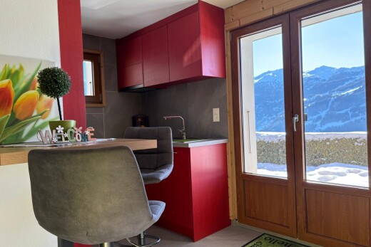 cuisine avec armoires rouges, natural light, lumière naturelle, inside property, et mountain view