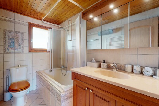 salle de bains avec tile wall, mur en carrelage, douche-bain combinés, natural light, et lumière naturelle