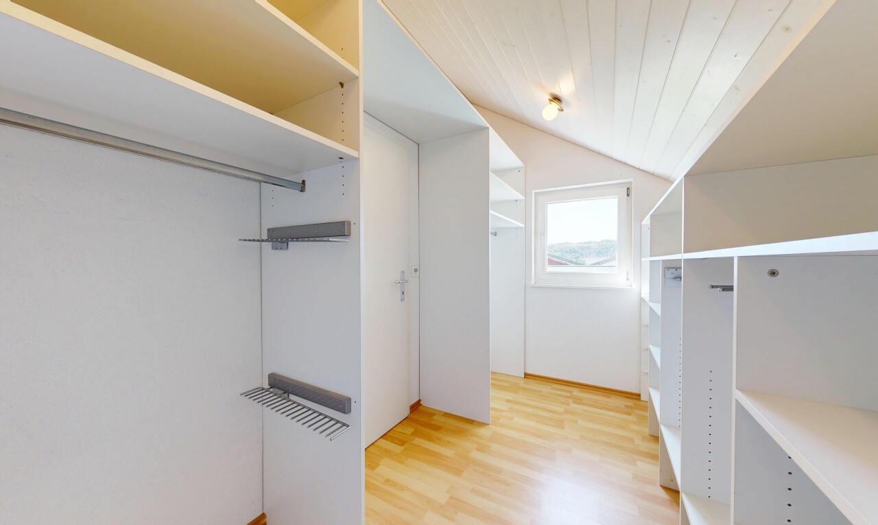 begehbarer kleiderschrank mit natürliches licht, begehbarer kleiderschrank, vaulted ceiling, dachschräge, und wood finish floor