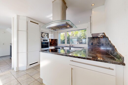 cuisine avec dark countertops, hotte, light floor, white cabinets, et armoires blanches
