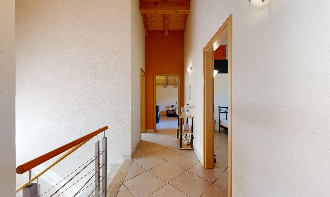 hall with a high wood beamed ceiling and light tile patterned floors