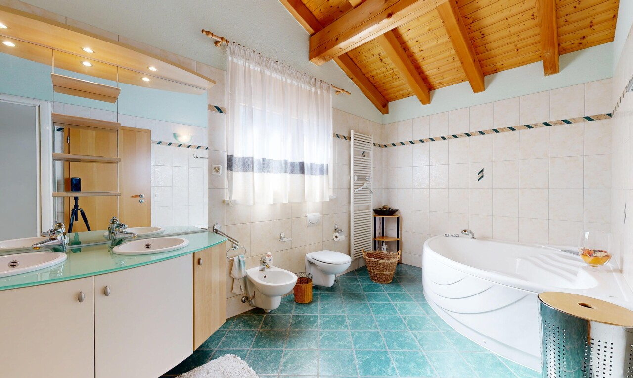 bathroom featuring a bath, double vanity, tile walls, a bidet, and a towel warming rack