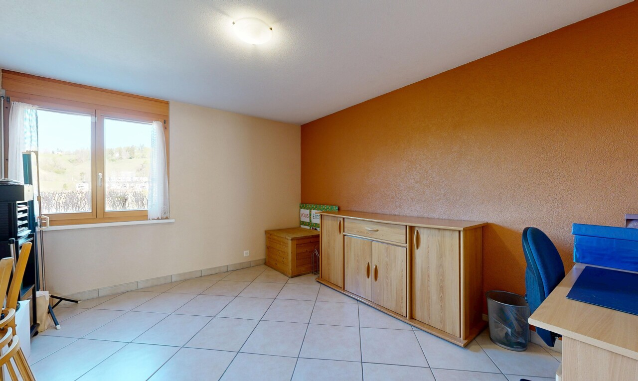 unfurnished room featuring a desk and light tile patterned floors