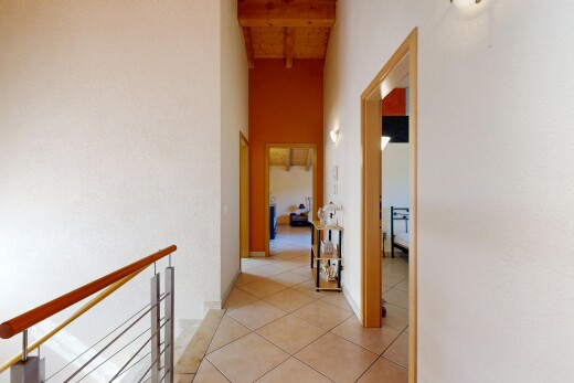 hall with a high wood beamed ceiling and light tile patterned floors