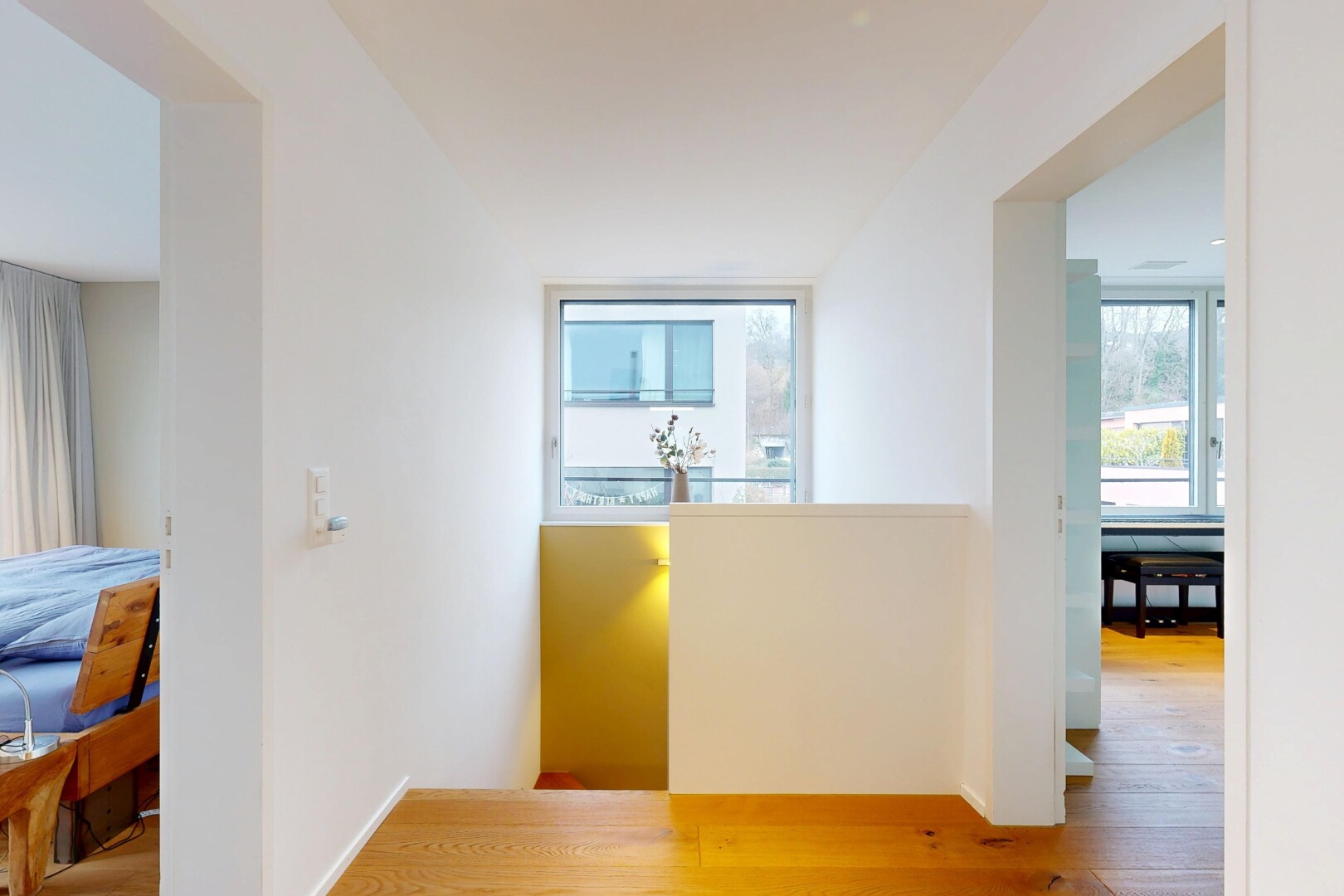 couloir avec wood finish floor, sol en finition bois, drywall, cloison sèche, et natural light