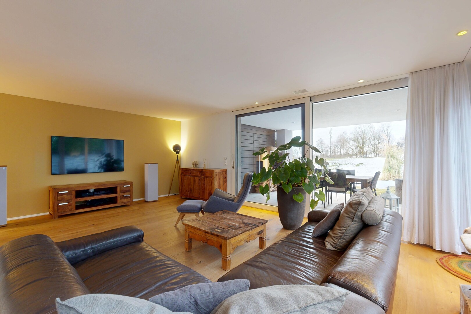 salon avec télévision, wood finish floor, sol en finition bois, floor ceiling windows, et fenêtres du sol au plafond