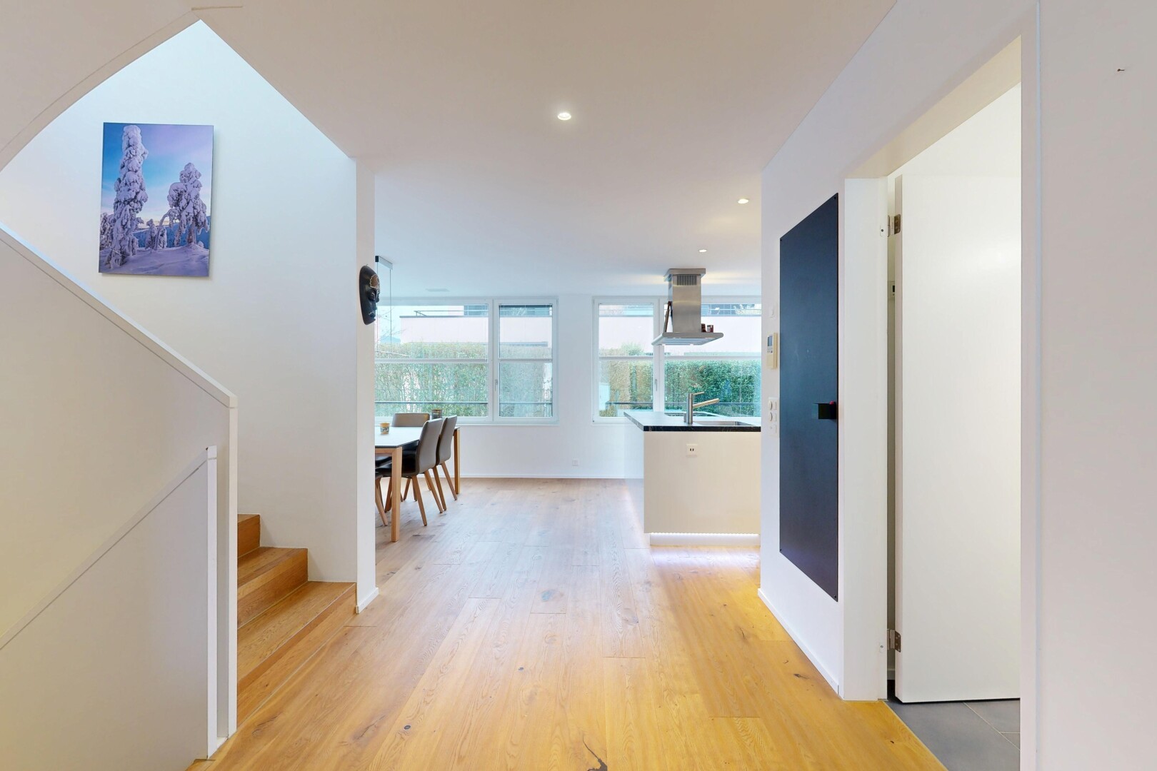 couloir avec inside property, cloison sèche, drywall, sol en finition bois, et wood finish floor