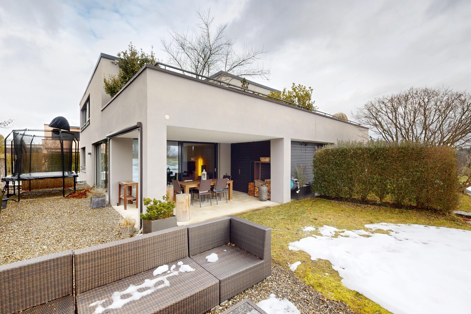 façade avec trampoline, terrasse, espace de vie extérieur, bardage en stuc, et property visible