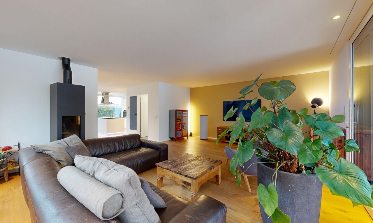 salon avec wood finish floor, sol en finition bois, drywall, cloison sèche, et natural light