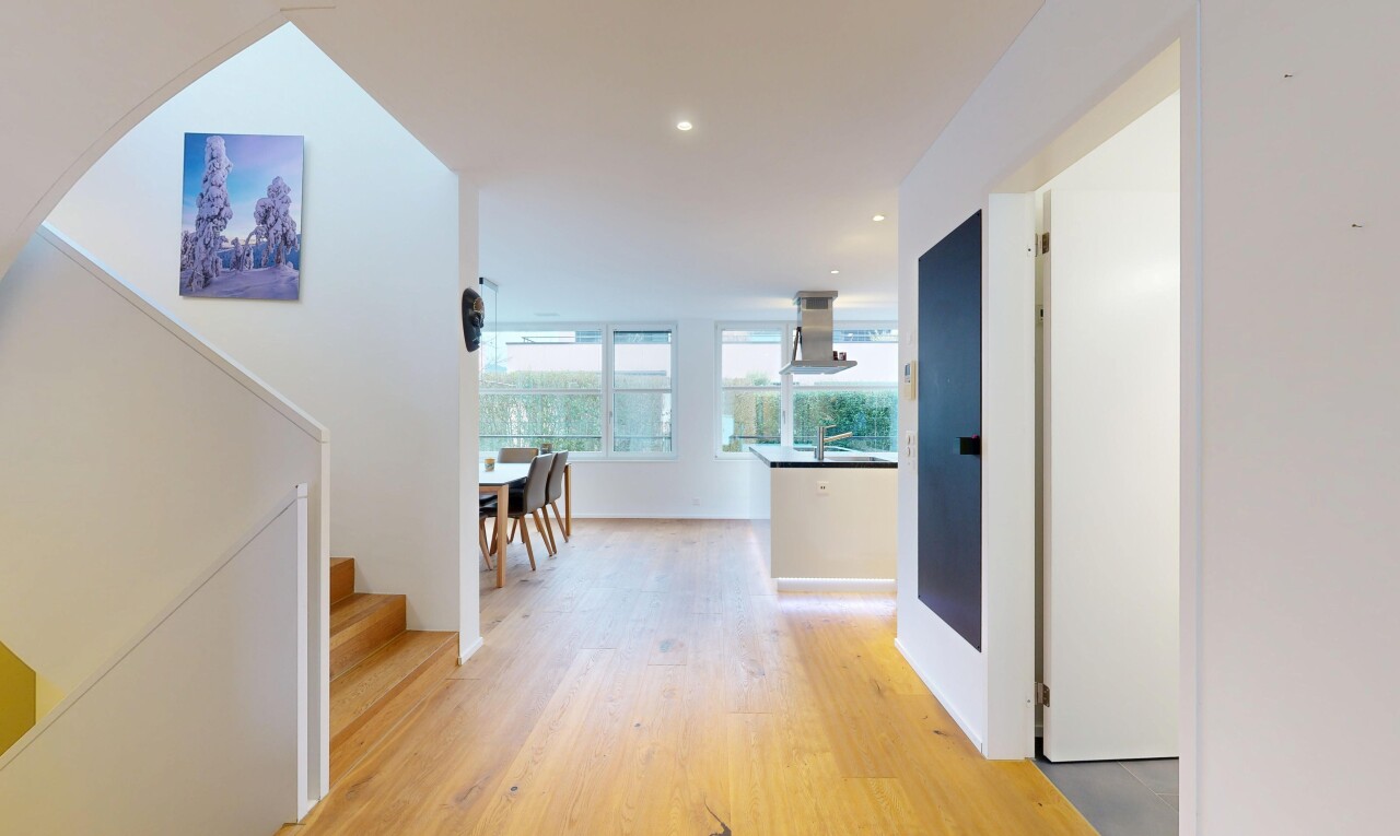 couloir avec inside property, cloison sèche, drywall, sol en finition bois, et wood finish floor