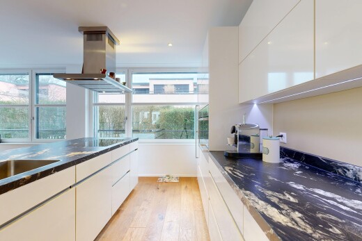 küche mit dark countertops, white cabinets, weiße schränke, dunstabzugshaube, und flat panel cabinets