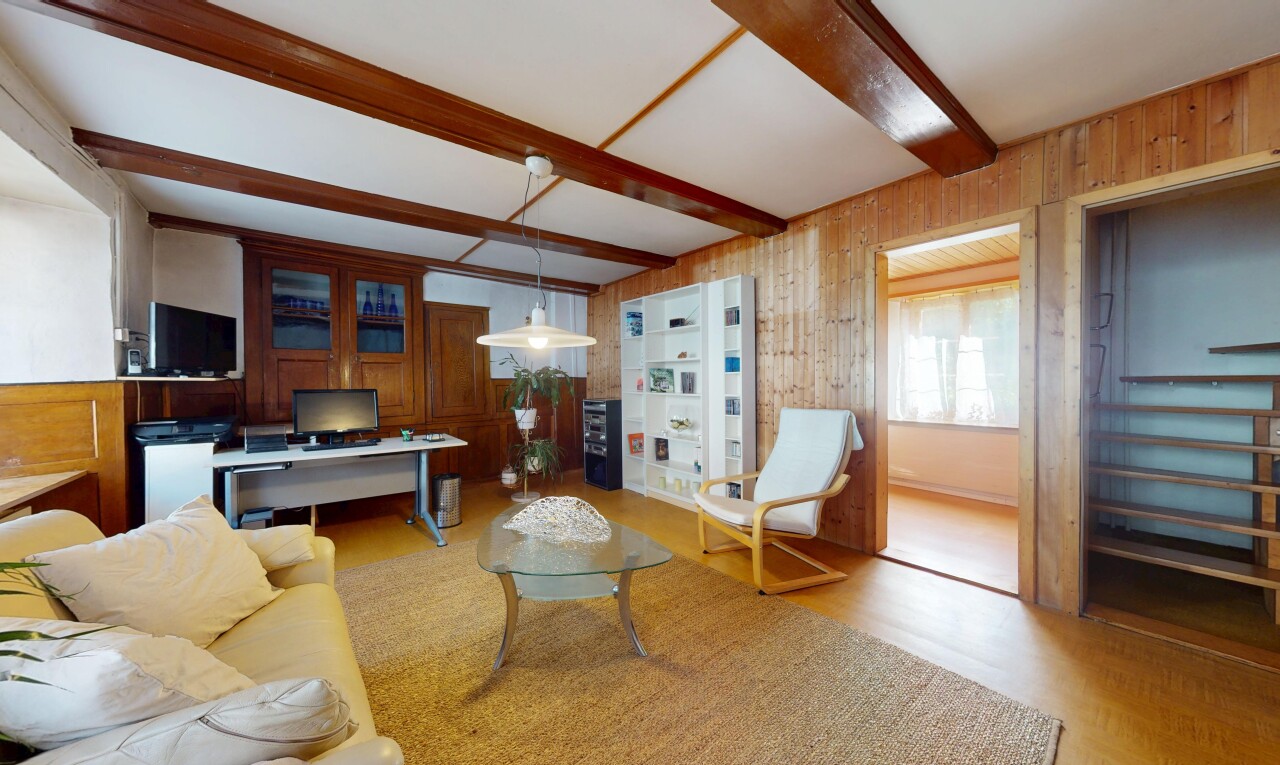 salon avec wood finish floor, sol en finition bois, beamed ceiling, plafond à poutres, et inside property