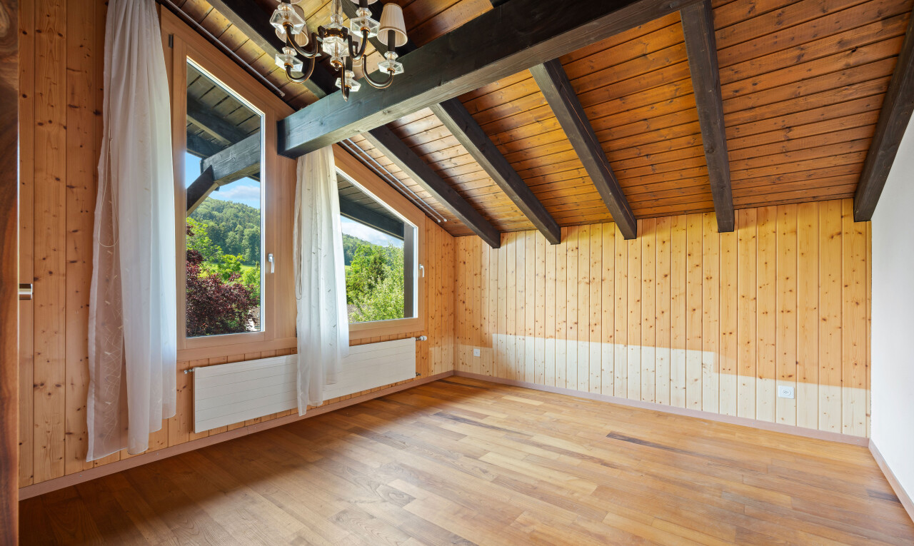 unfurnished room with a chandelier, light wood finished floors, wooden ceiling, lofted ceiling with beams, and wooden walls