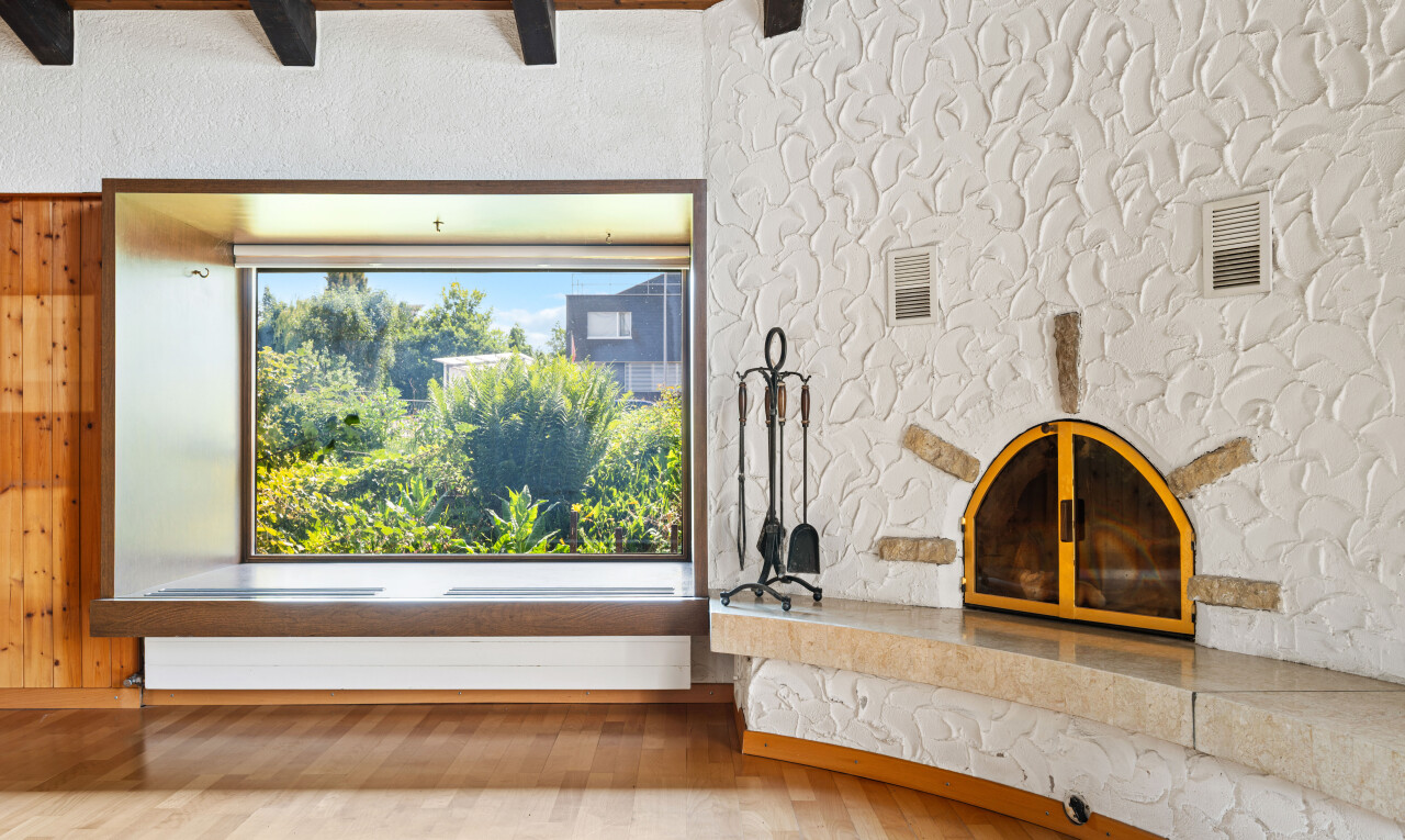 unfurnished living room featuring light wood finished floors and beam ceiling