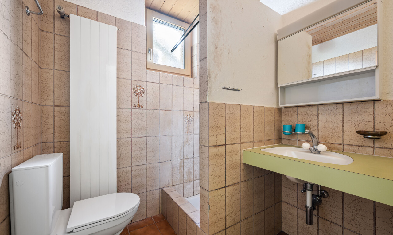 bathroom featuring a shower, tile walls, and dark tile patterned floors