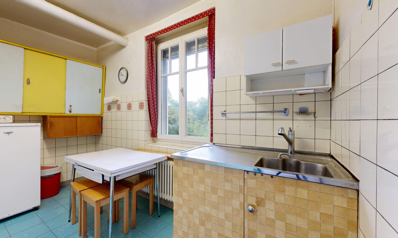 cuisine avec mur en carrelage, tile wall, évier, radiateur, et light floor