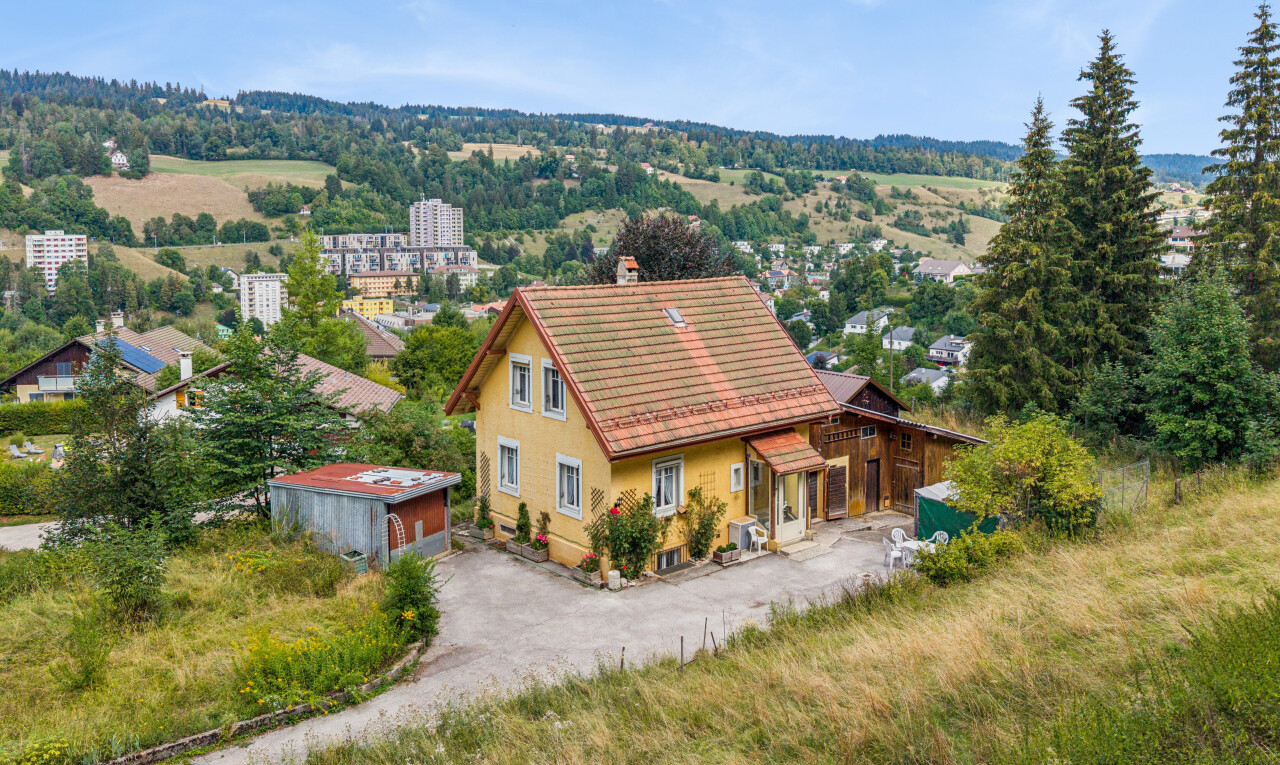 façade avec day time, property visible, structure extérieure, et drone view