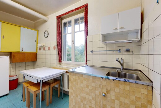 cuisine avec mur en carrelage, tile wall, évier, radiateur, et light floor