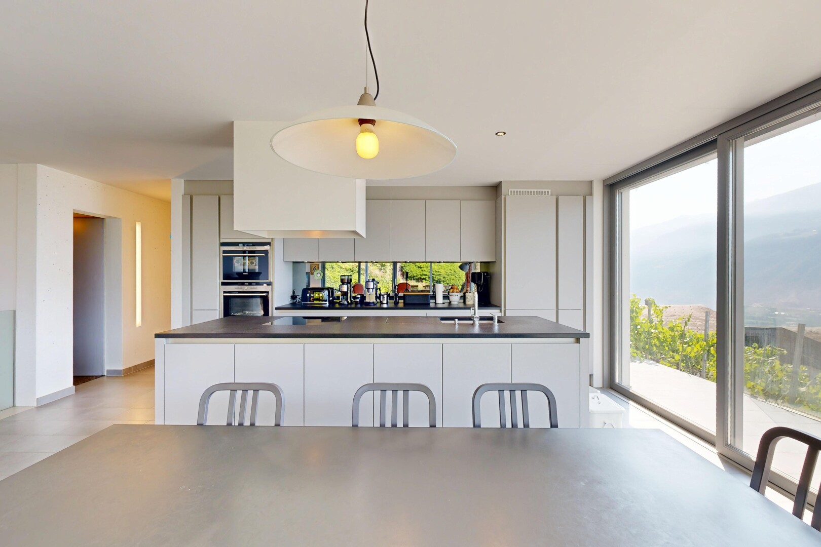 cuisine avec pendant lighting, éclairage suspendu, inside property, light floor, et full kitchen